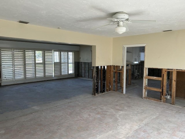 unfurnished room featuring a textured ceiling, visible vents, and a ceiling fan