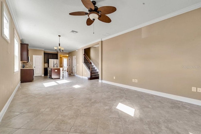 unfurnished living room with light tile patterned floors, ceiling fan with notable chandelier, a wealth of natural light, and ornamental molding