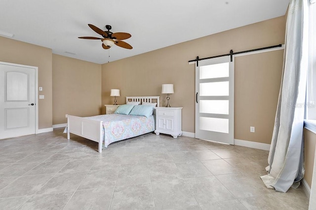 bedroom featuring a barn door and ceiling fan