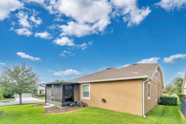 back of house with a sunroom and a lawn