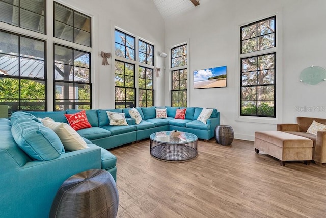 living room with hardwood / wood-style floors, beamed ceiling, and high vaulted ceiling