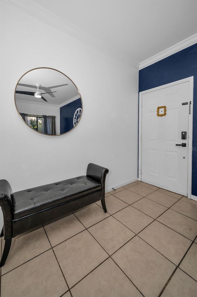 tiled foyer with ceiling fan and ornamental molding