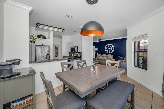 dining area featuring light tile patterned floors and ornamental molding