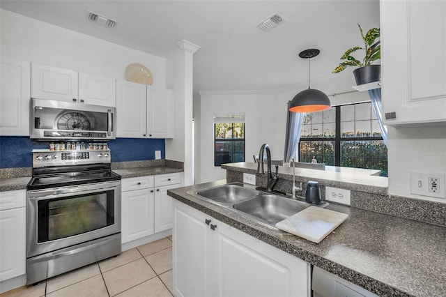 kitchen featuring stainless steel appliances, sink, light tile patterned floors, pendant lighting, and white cabinetry