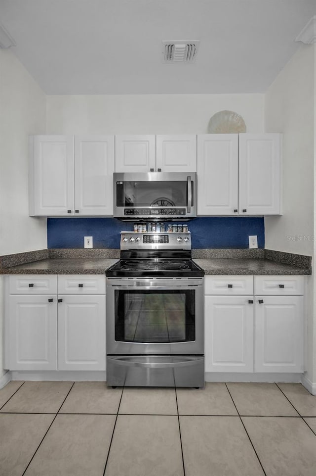 kitchen featuring white cabinets, appliances with stainless steel finishes, and light tile patterned floors