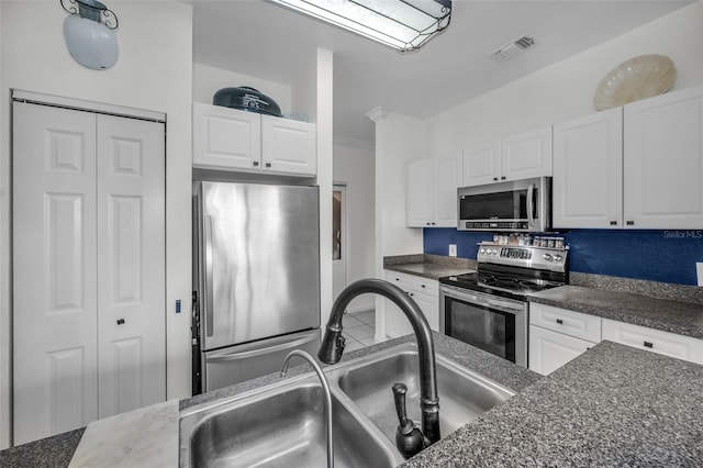 kitchen with dark stone countertops, sink, white cabinets, and appliances with stainless steel finishes