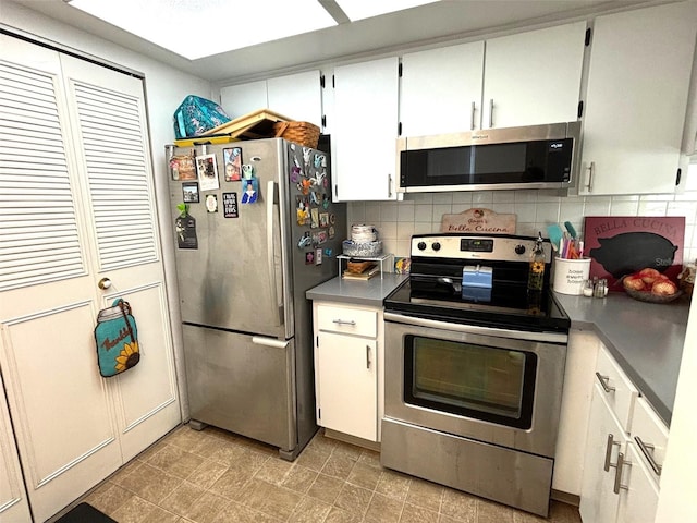 kitchen with decorative backsplash, stainless steel appliances, and white cabinetry