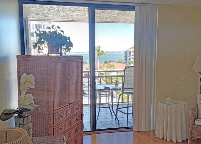 doorway to outside with hardwood / wood-style floors and a water view