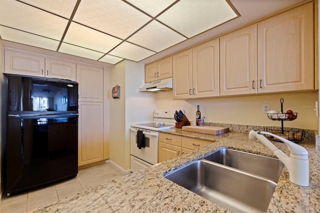 kitchen featuring sink, black fridge, light stone counters, white range with electric stovetop, and light tile patterned floors