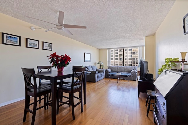 dining area featuring hardwood / wood-style floors, ceiling fan, and a textured ceiling