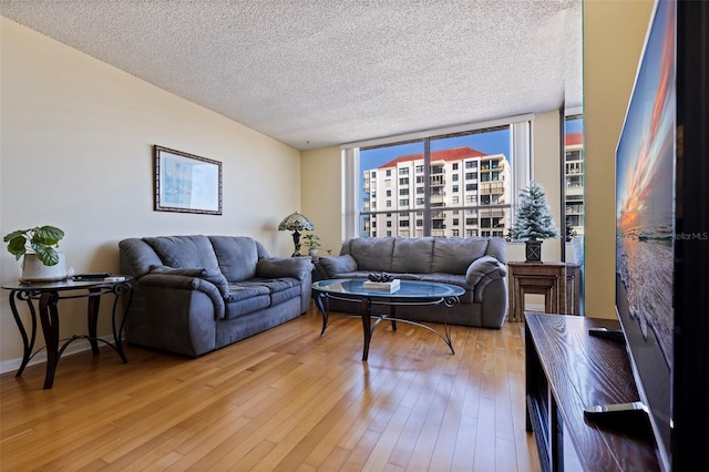 living room with hardwood / wood-style flooring, expansive windows, and a textured ceiling