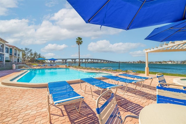 view of pool featuring a water view and a patio area