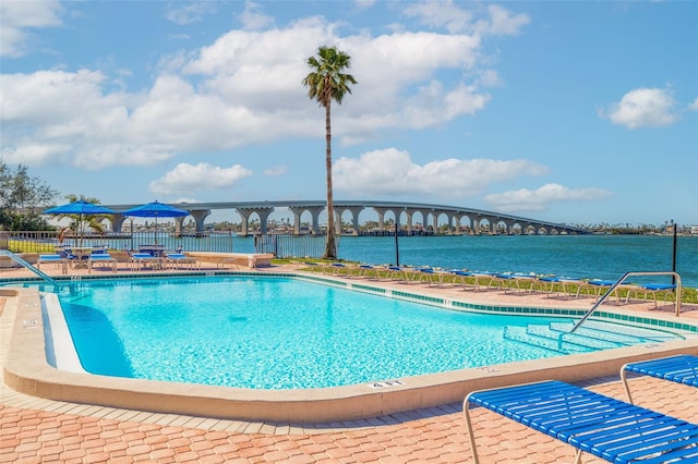 view of pool with a patio area and a water view