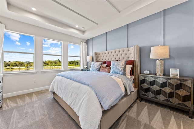 bedroom featuring carpet floors and a tray ceiling