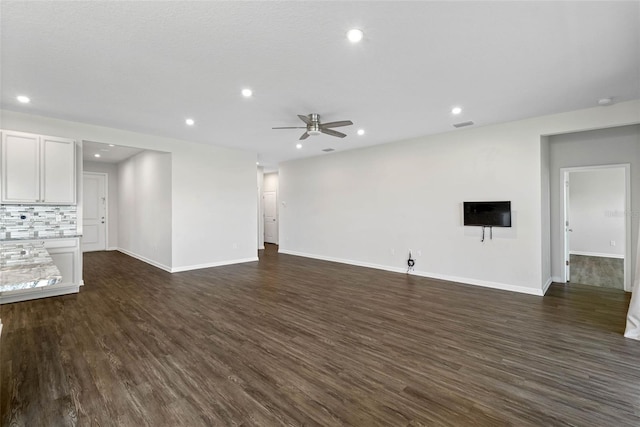 unfurnished living room with dark hardwood / wood-style floors and ceiling fan