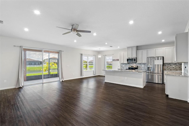 kitchen with ceiling fan, white cabinetry, dark hardwood / wood-style flooring, a kitchen island, and appliances with stainless steel finishes