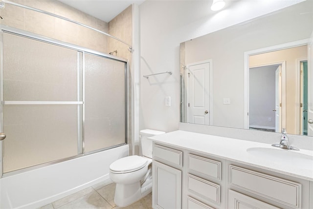 full bathroom featuring shower / bath combination with glass door, vanity, tile patterned floors, and toilet