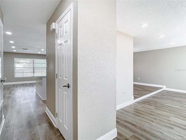 hallway with hardwood / wood-style floors