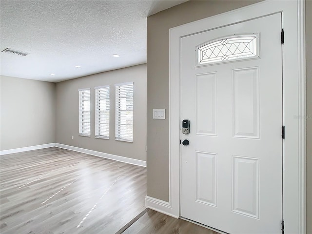 foyer with wood-type flooring and a textured ceiling