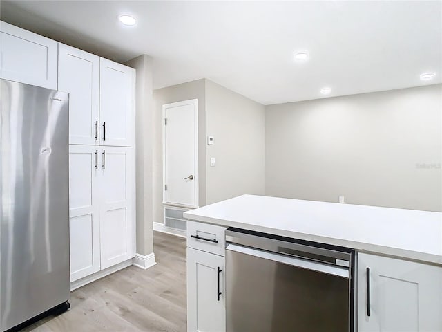 kitchen featuring white cabinets, light wood-type flooring, and stainless steel appliances