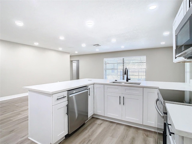 kitchen featuring appliances with stainless steel finishes, white cabinetry, and sink