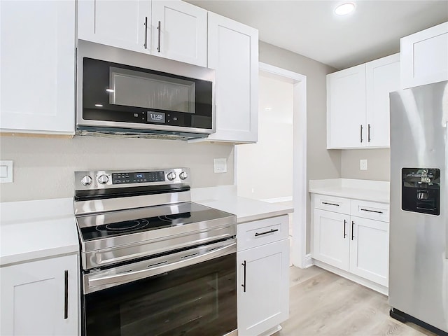 kitchen featuring appliances with stainless steel finishes, light hardwood / wood-style floors, and white cabinetry