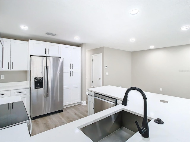 kitchen featuring white cabinetry, light hardwood / wood-style flooring, stainless steel appliances, and sink