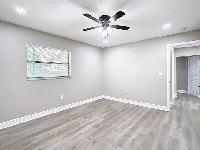 spare room with ceiling fan, light wood-type flooring, and a textured ceiling