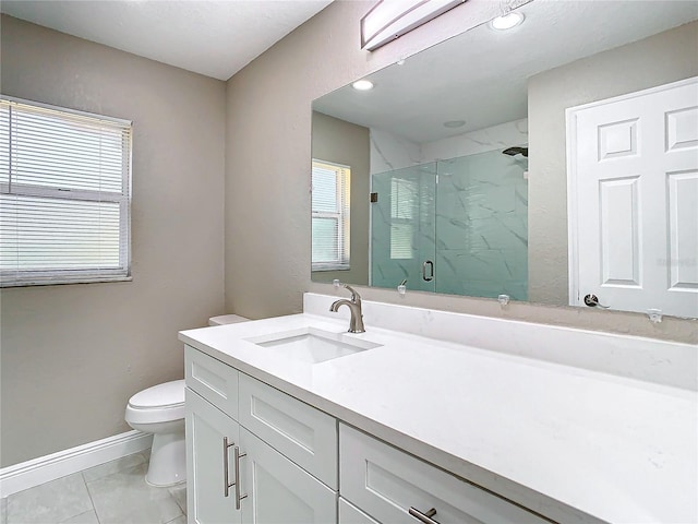 bathroom with tile patterned floors, vanity, a healthy amount of sunlight, and toilet