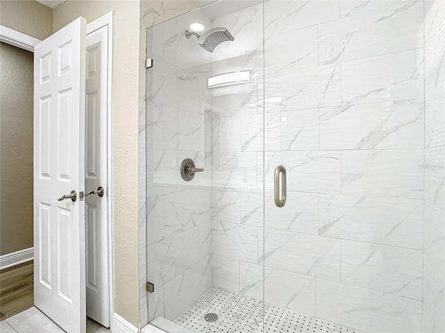 bathroom with a shower with door