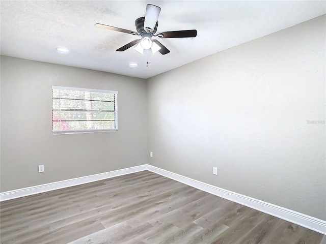 empty room with ceiling fan and wood-type flooring