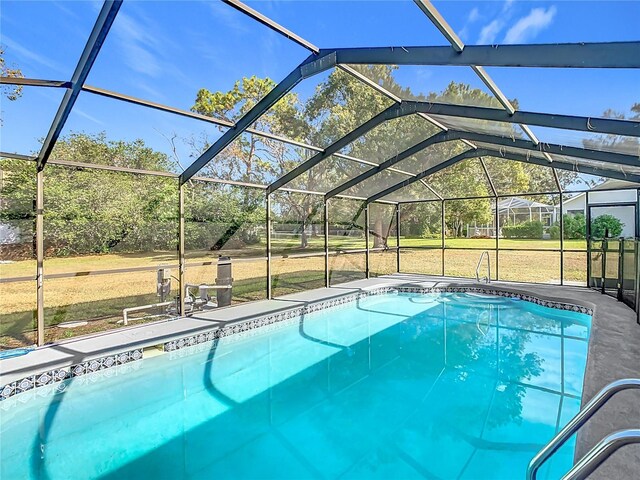 view of pool featuring a lawn and glass enclosure