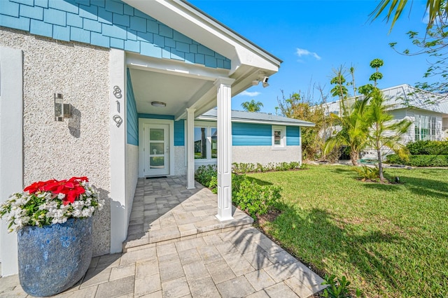 view of exterior entry featuring a yard