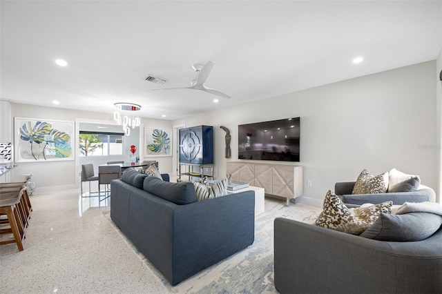 living room featuring ceiling fan with notable chandelier