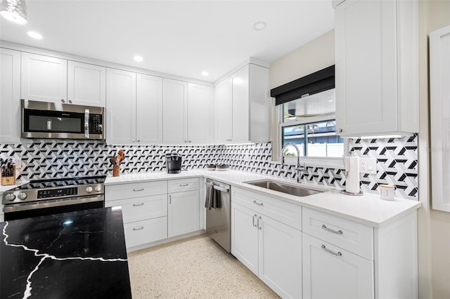 kitchen with backsplash, sink, white cabinets, and stainless steel appliances