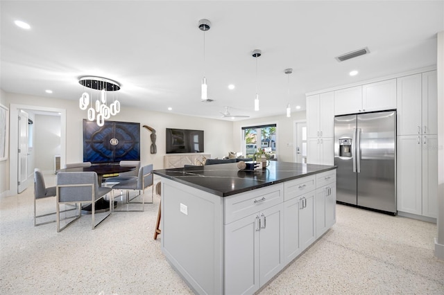 kitchen featuring stainless steel fridge with ice dispenser, white cabinets, decorative light fixtures, and ceiling fan