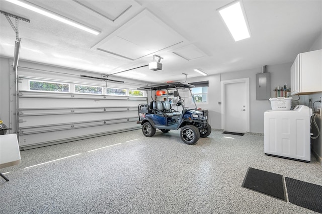 garage with electric panel, a garage door opener, and washer / dryer