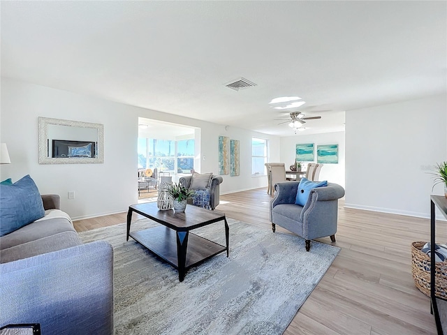 living room featuring light hardwood / wood-style flooring and ceiling fan