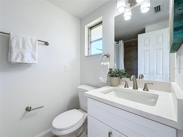 bathroom with vanity, toilet, and walk in shower