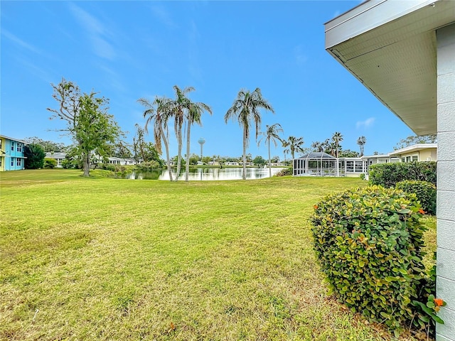 view of yard featuring a water view and glass enclosure