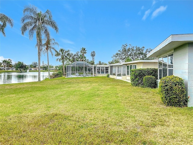 view of yard with a water view and a lanai