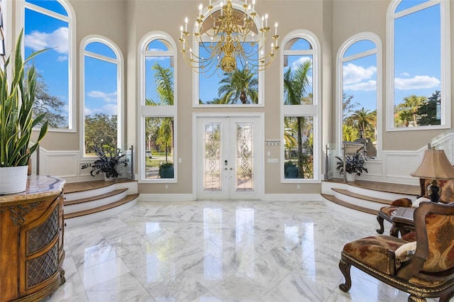 sunroom / solarium with a notable chandelier, a healthy amount of sunlight, and french doors