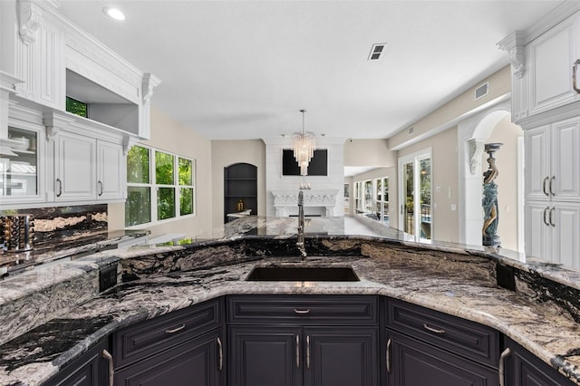 kitchen featuring plenty of natural light, a sink, and white cabinets