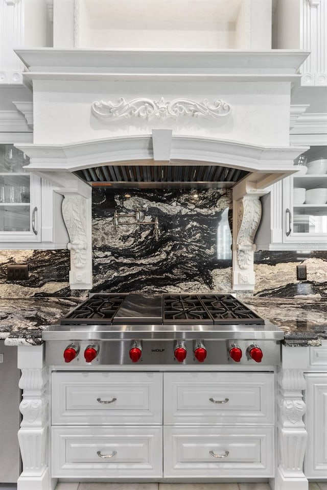 room details with glass insert cabinets, white cabinets, and stainless steel gas cooktop