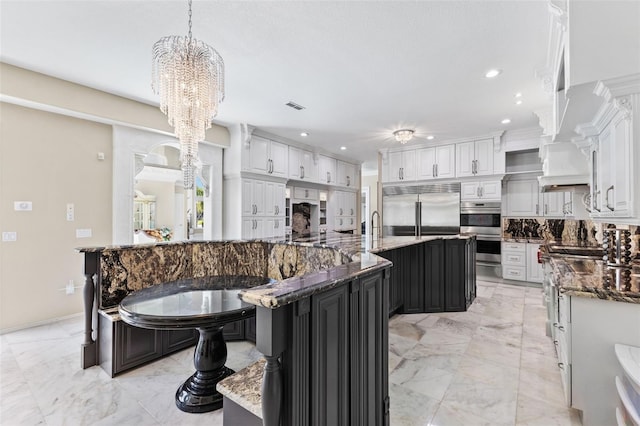 kitchen featuring marble finish floor, a spacious island, visible vents, backsplash, and appliances with stainless steel finishes