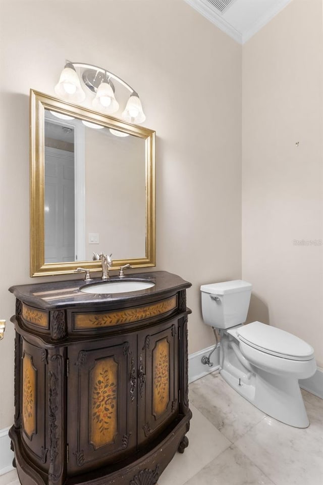 half bathroom with toilet, baseboards, ornamental molding, and vanity