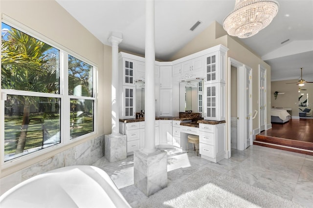 bathroom featuring vanity, visible vents, vaulted ceiling, marble finish floor, and a soaking tub