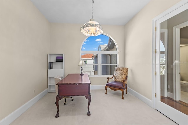 carpeted home office featuring baseboards and an inviting chandelier