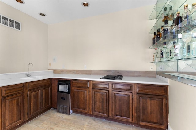 kitchen featuring light wood-style floors, visible vents, light countertops, and a sink