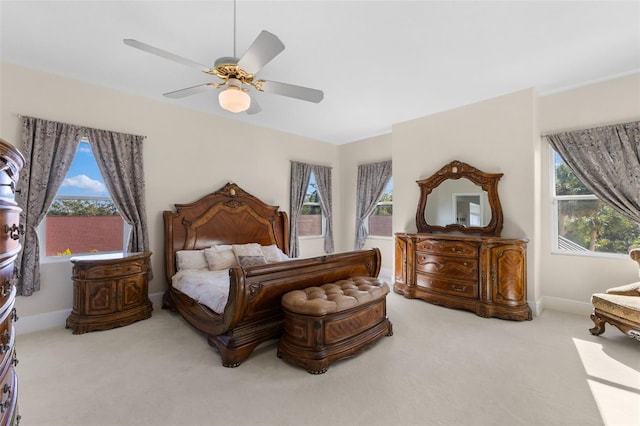 bedroom with carpet flooring, ceiling fan, baseboards, and multiple windows